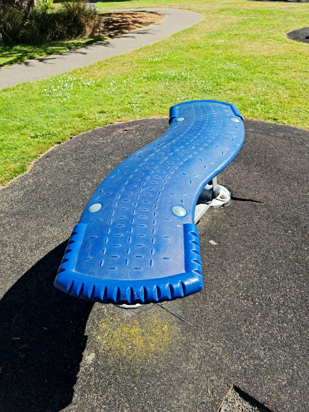 a blue bench sitting in the middle of a park