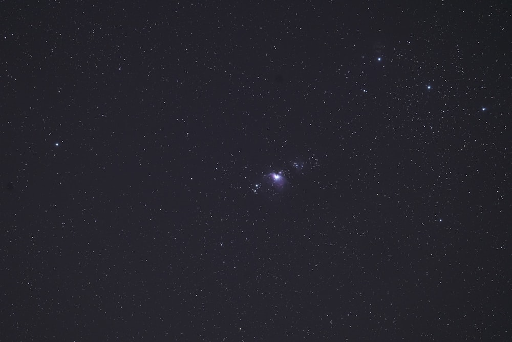 un cielo nocturno con estrellas y una luz brillante