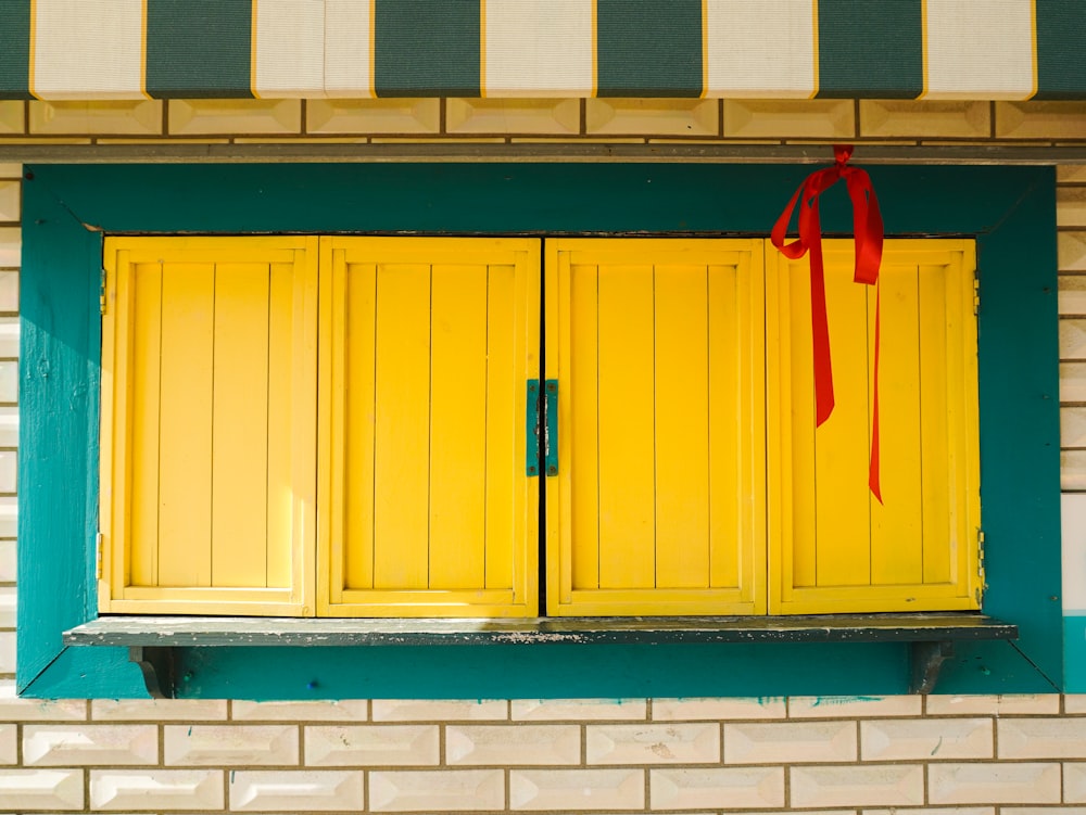 a yellow and green window with a red ribbon on it
