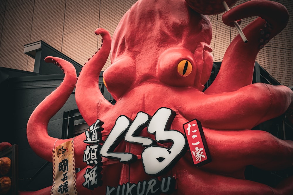 una estatua gigante de pulpo rojo frente a un edificio