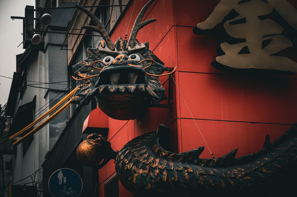 uma cabeça de dragão pendurada na lateral de um edifício