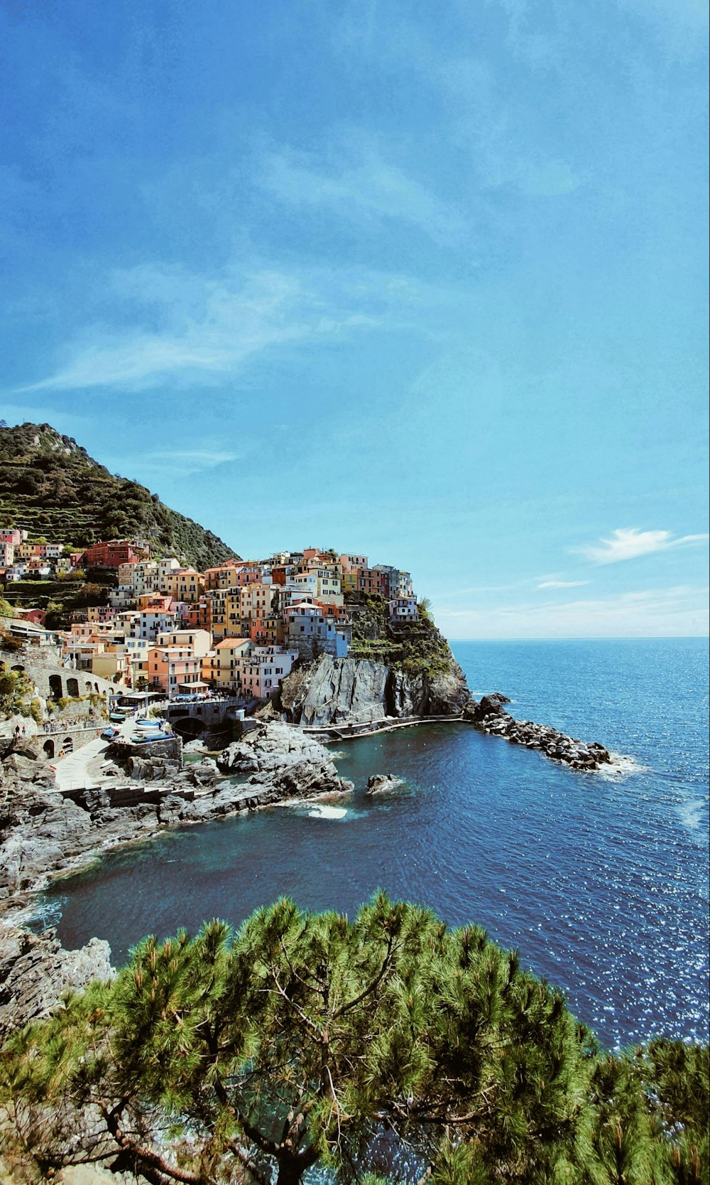 a scenic view of a small town on a cliff overlooking the ocean