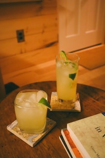 a wooden table topped with two glasses filled with drinks