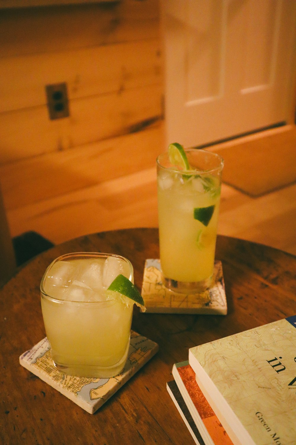 a wooden table topped with two glasses filled with drinks