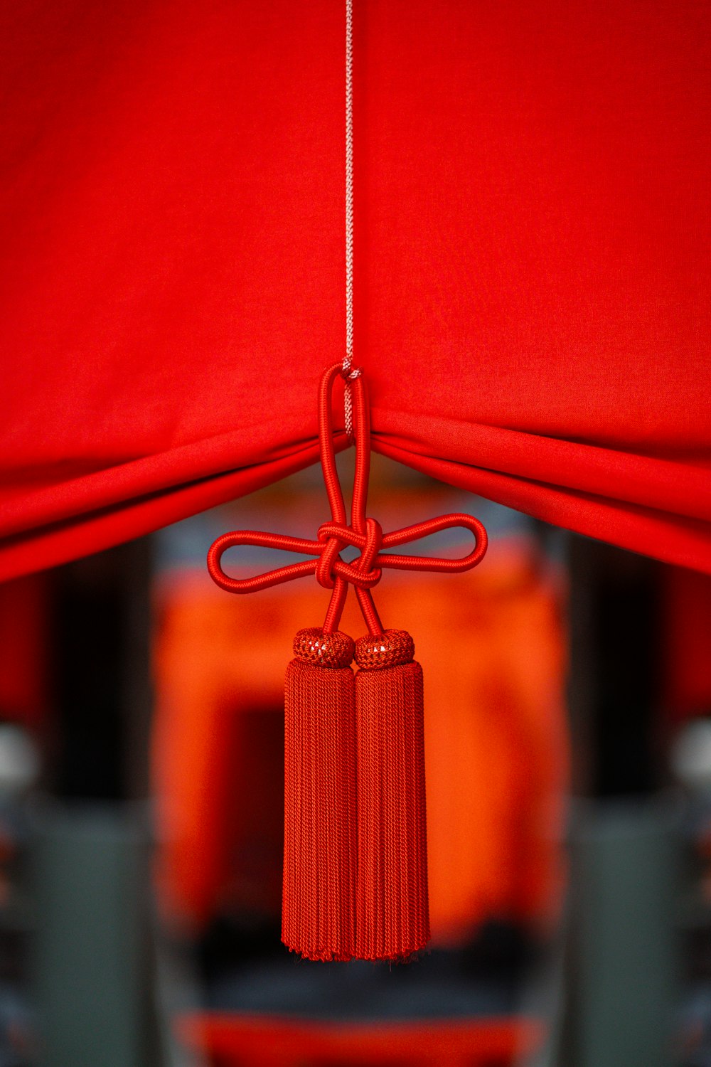 a red curtain with a tassel hanging from it
