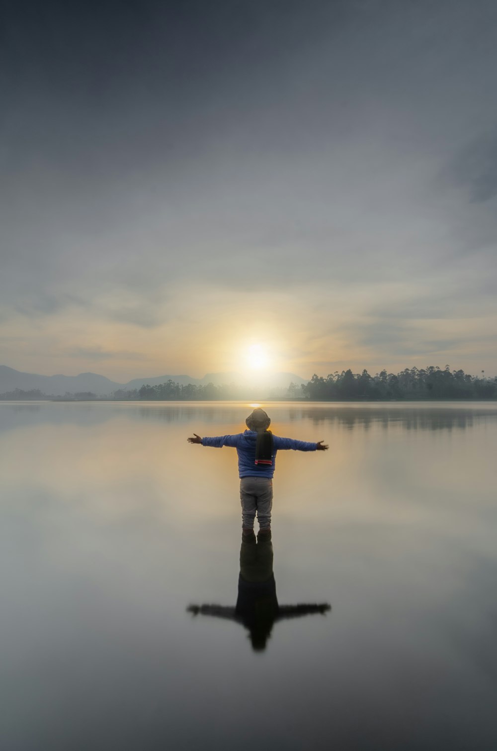 a person standing in the water with their arms outstretched