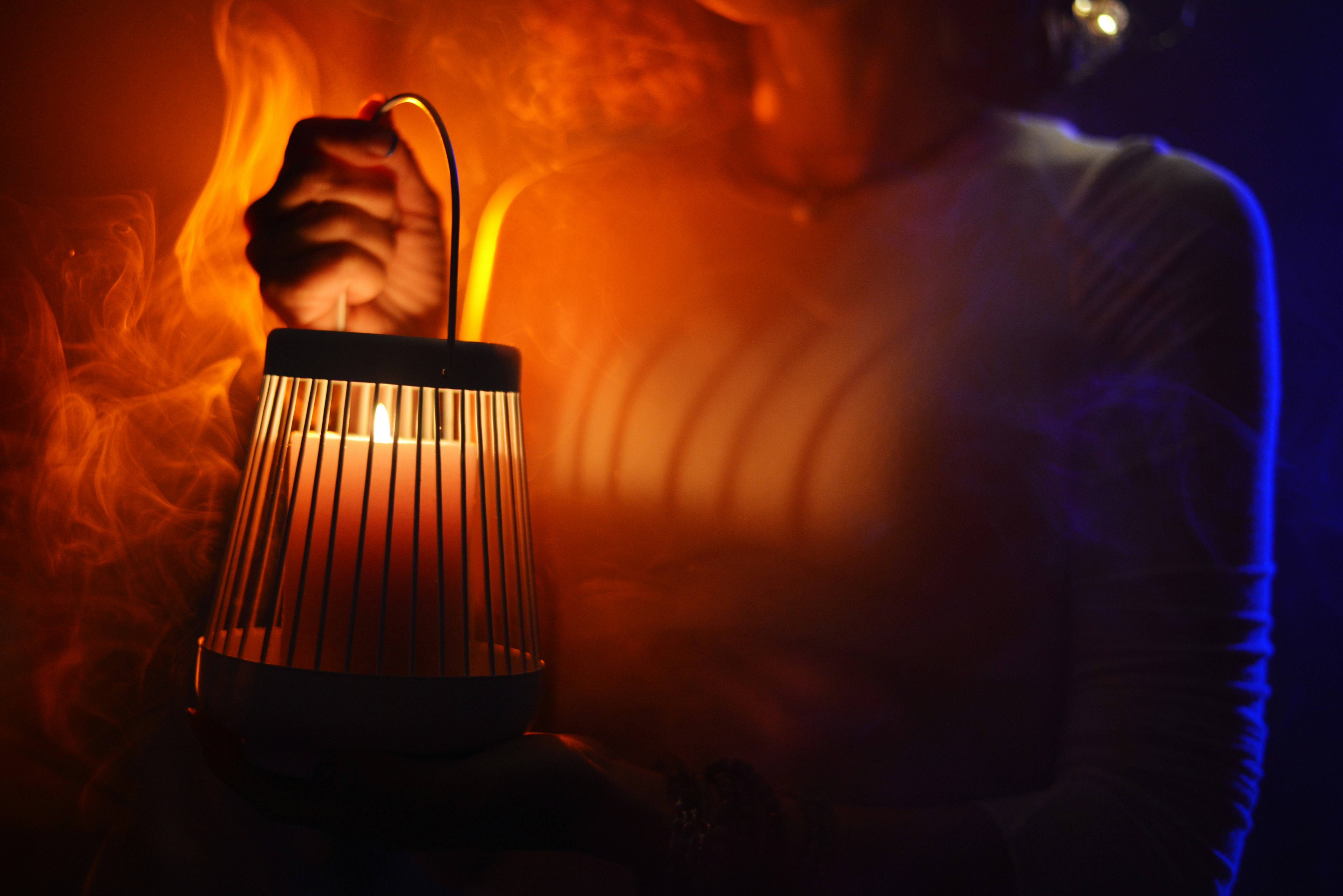 eine Person, die eine brennende Kerze in der Hand hält