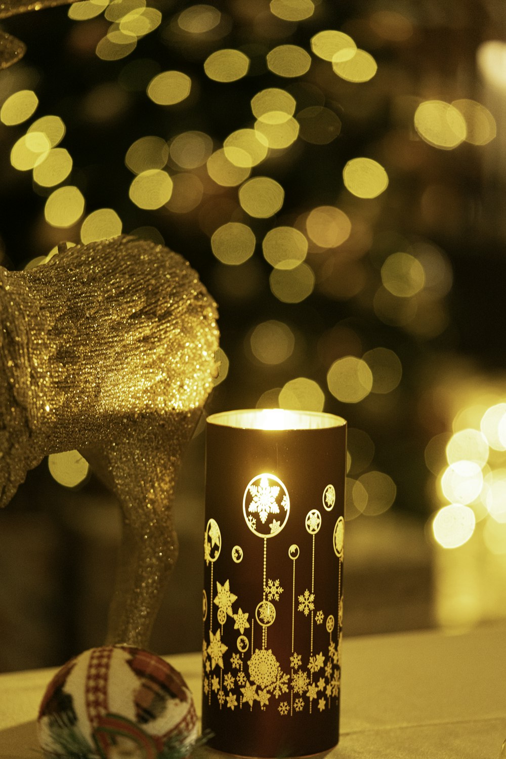 a lit candle sitting next to a christmas tree