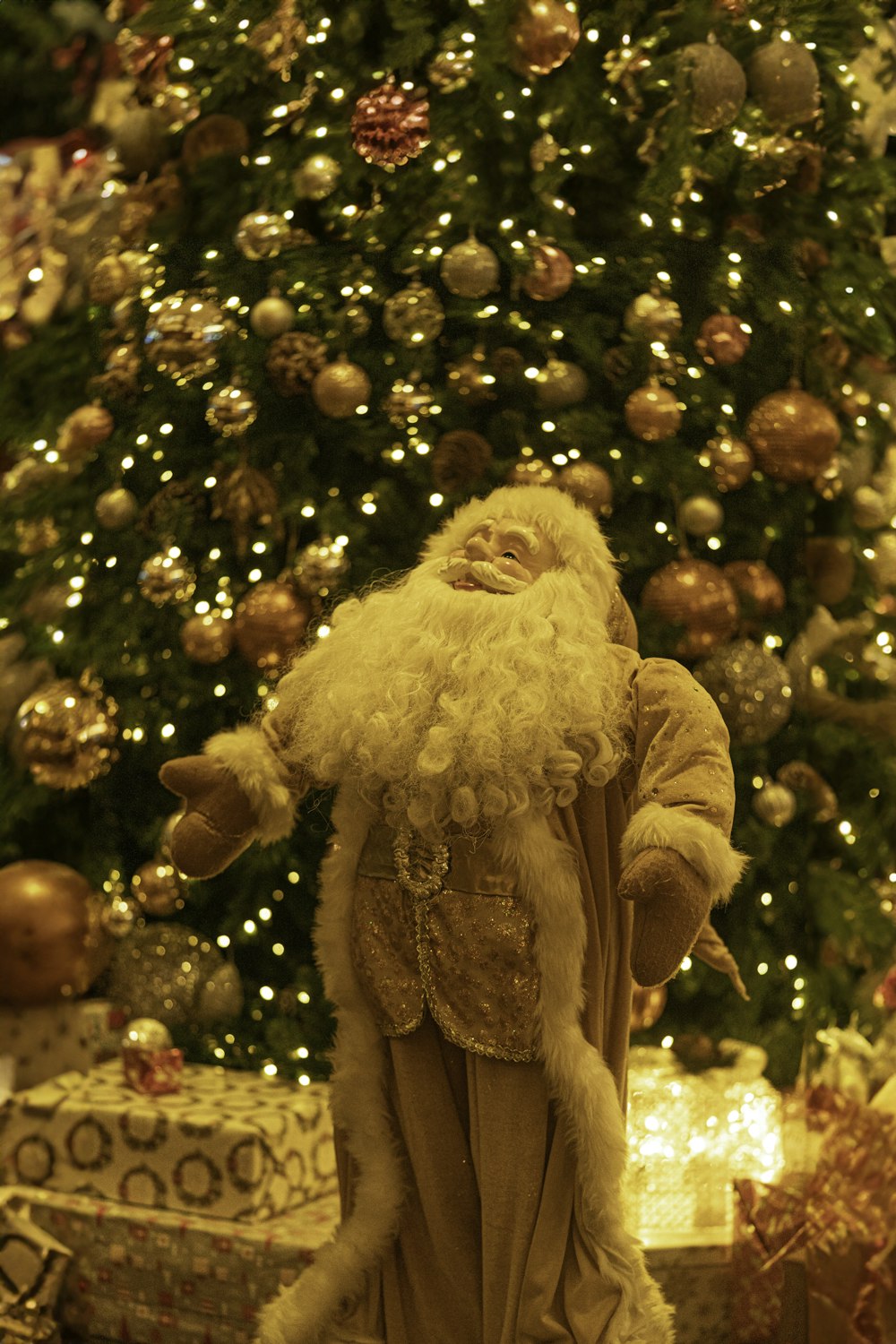 a santa clause standing in front of a christmas tree
