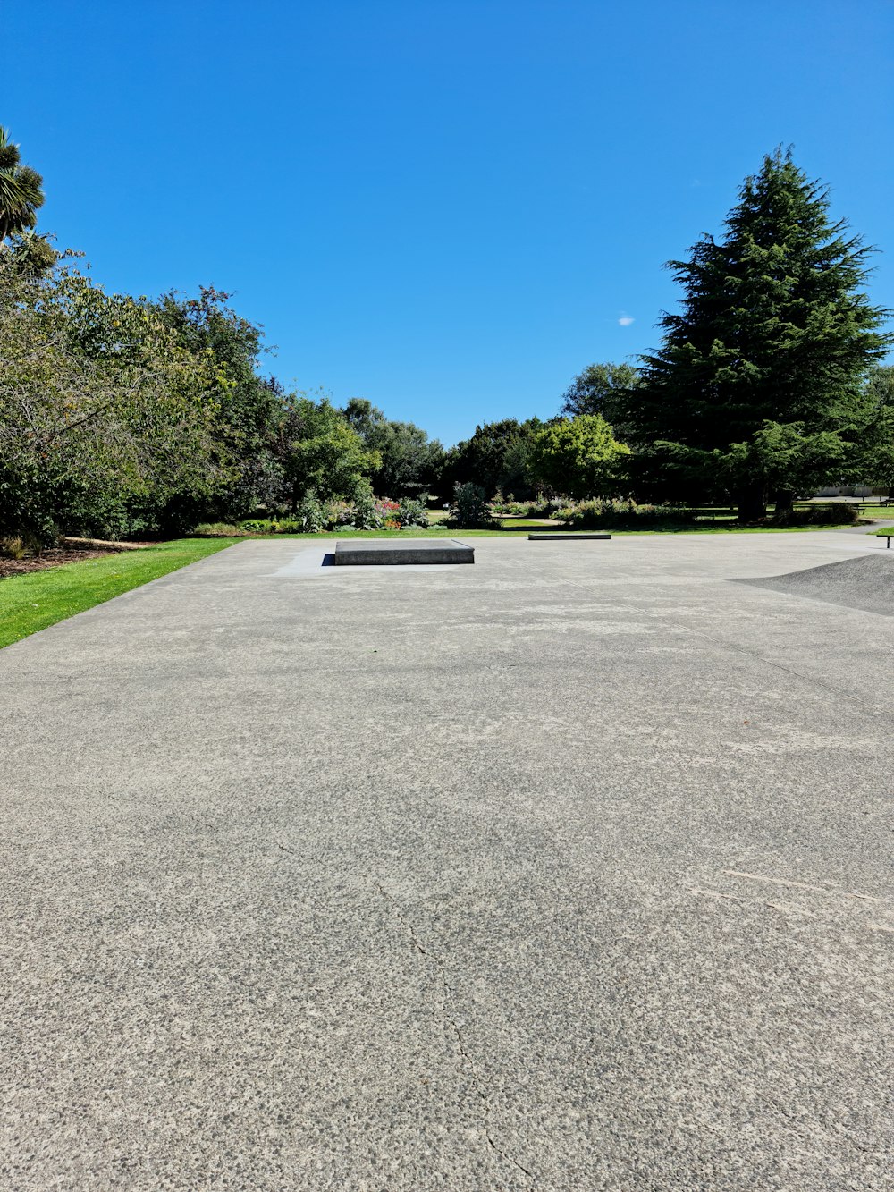 a concrete parking lot with a bench in the middle of it