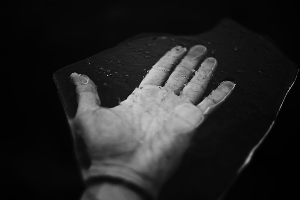 a black and white photo of a hand holding something