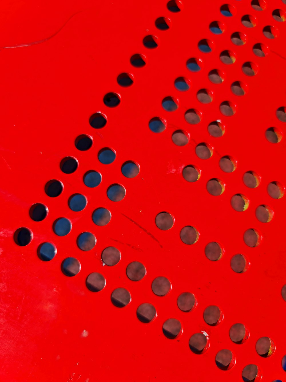 a close up of a red surface with circles on it
