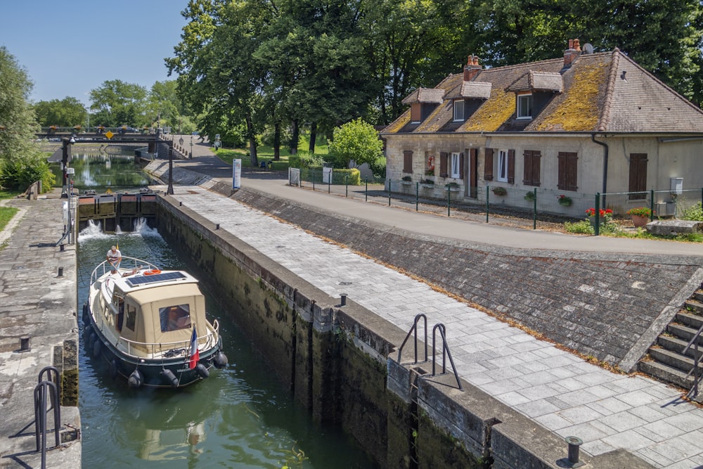 a boat traveling down a canal next to a house