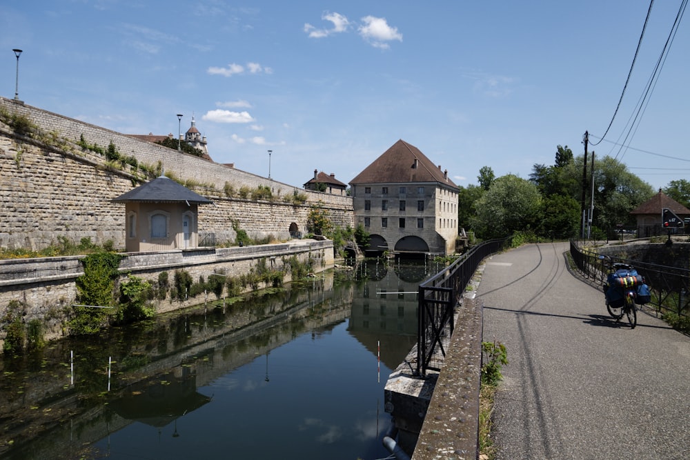 a man riding a bike down a street next to a river