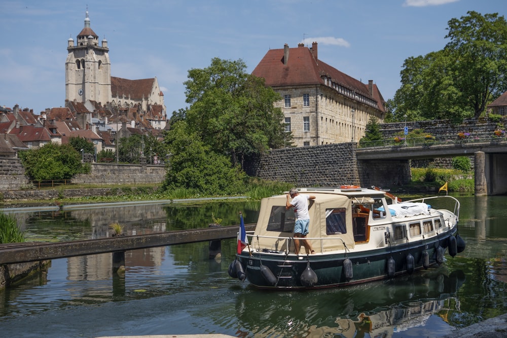 a small boat traveling down a river next to a bridge