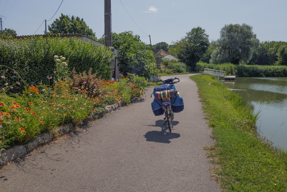 a person riding a bike down a road next to a river