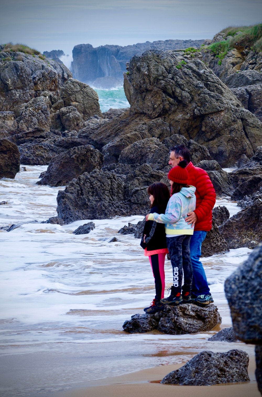 a group of people standing on top of a rocky beach