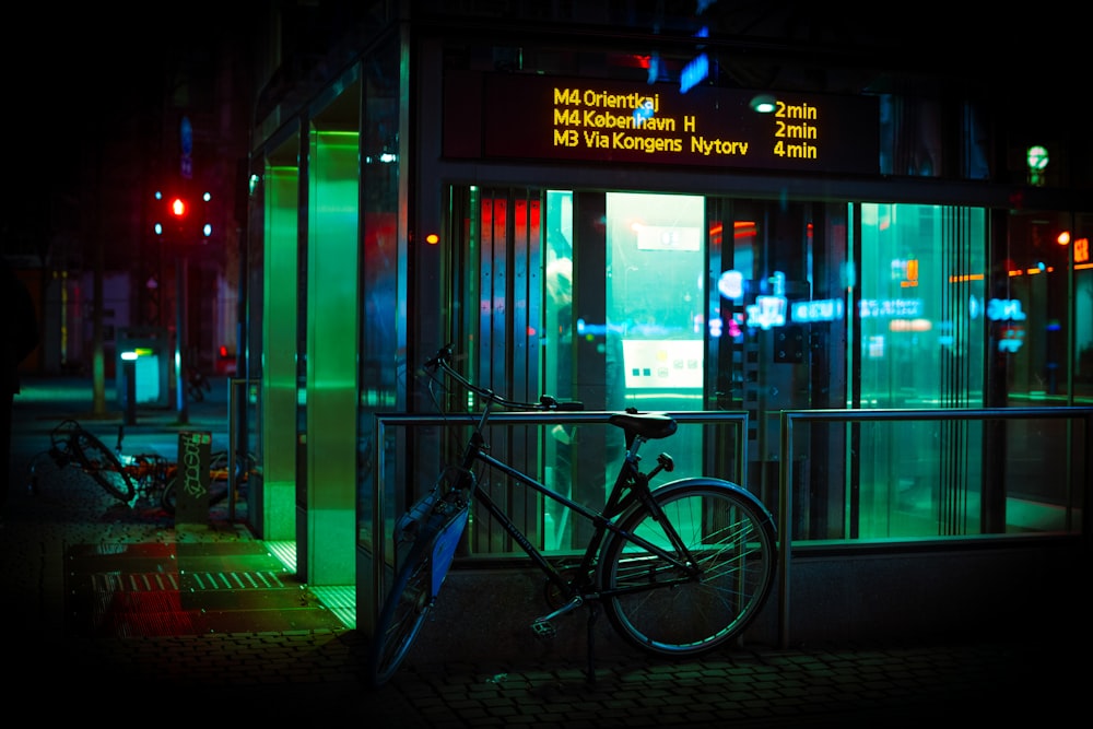a bicycle parked outside of a building at night