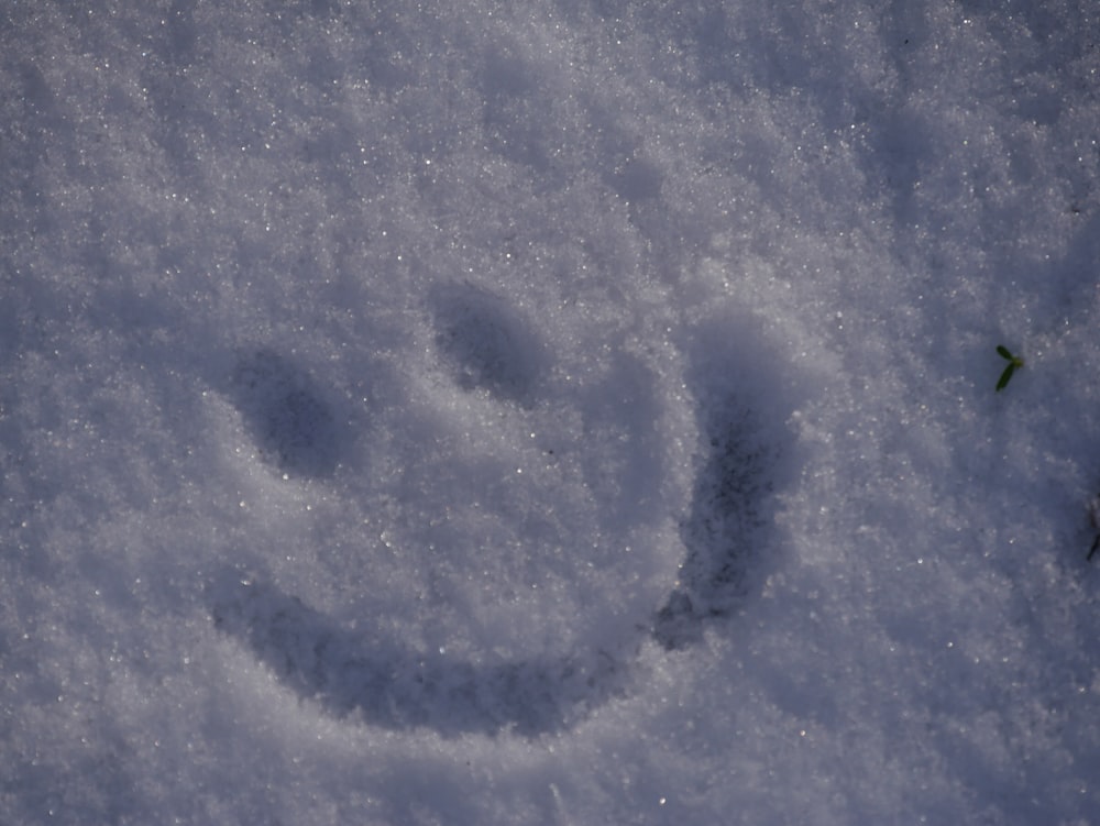 a smiley face drawn in the snow