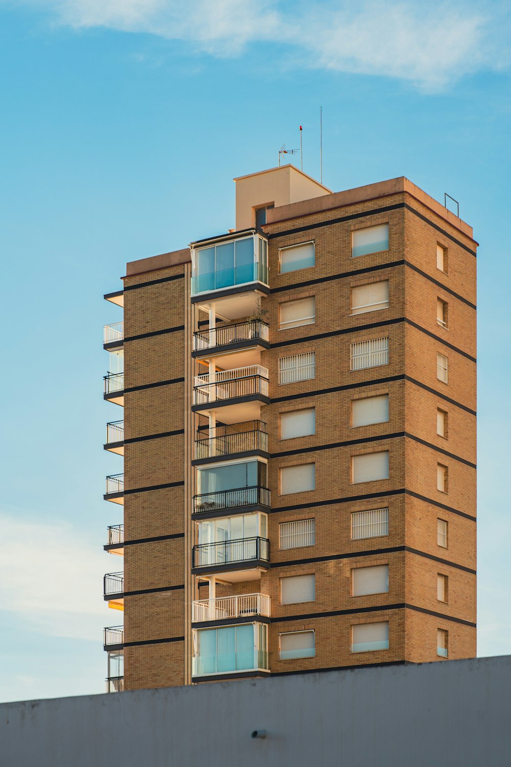 a tall brick building with balconies and balconies on top