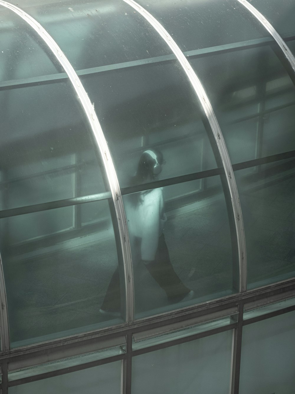 a person standing on a glass walkway in front of a building