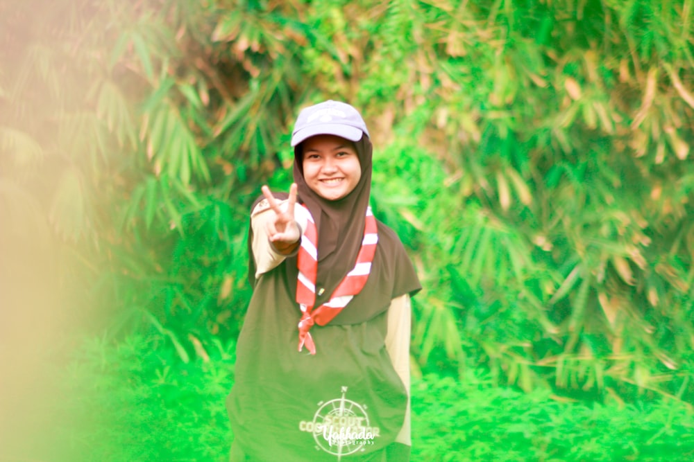 a woman in a green shirt and a red and white scarf