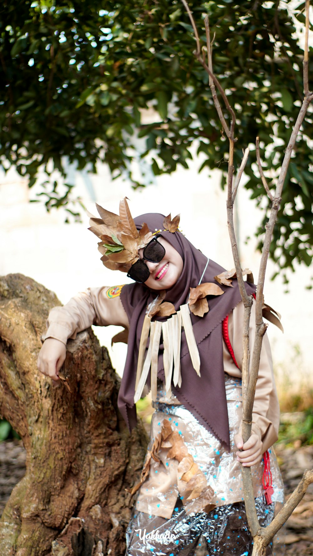 a woman in a costume standing next to a tree