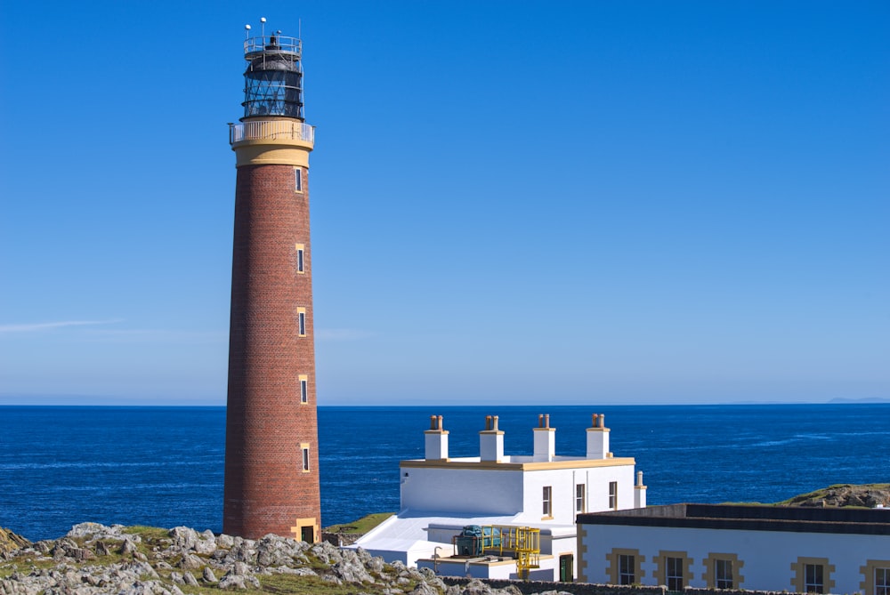 a light house sitting on top of a hill next to the ocean