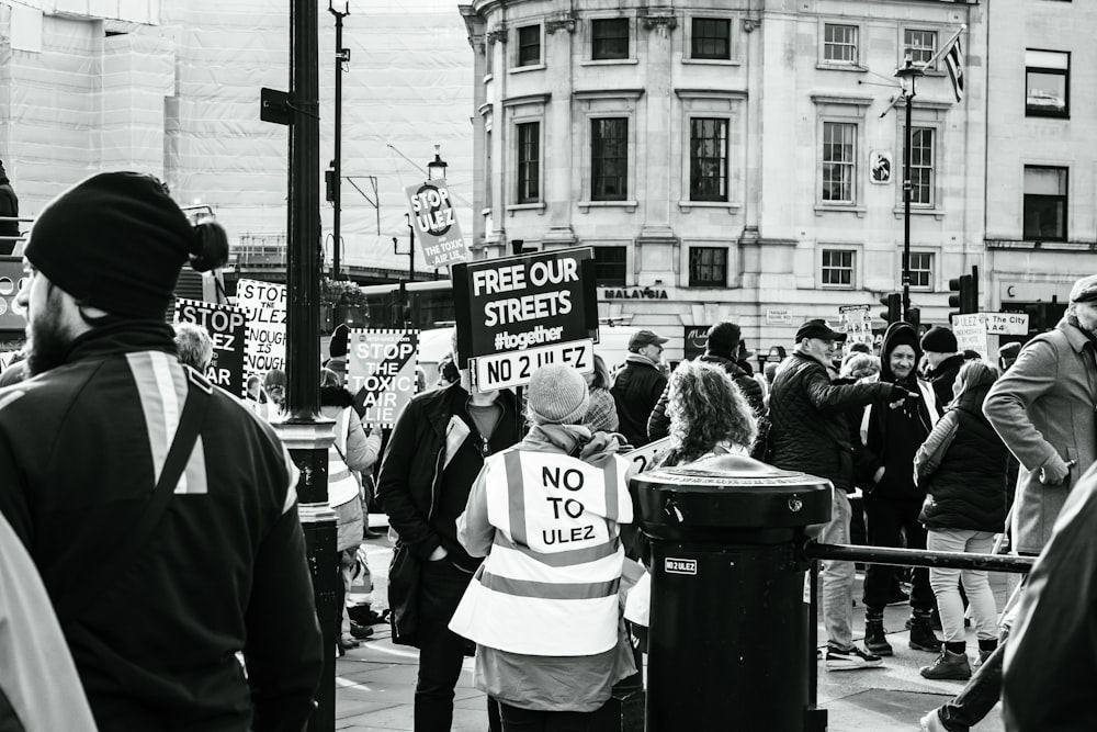 a group of people standing on a street corner