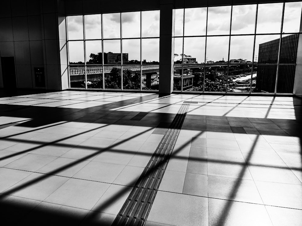 a black and white photo of a room with large windows