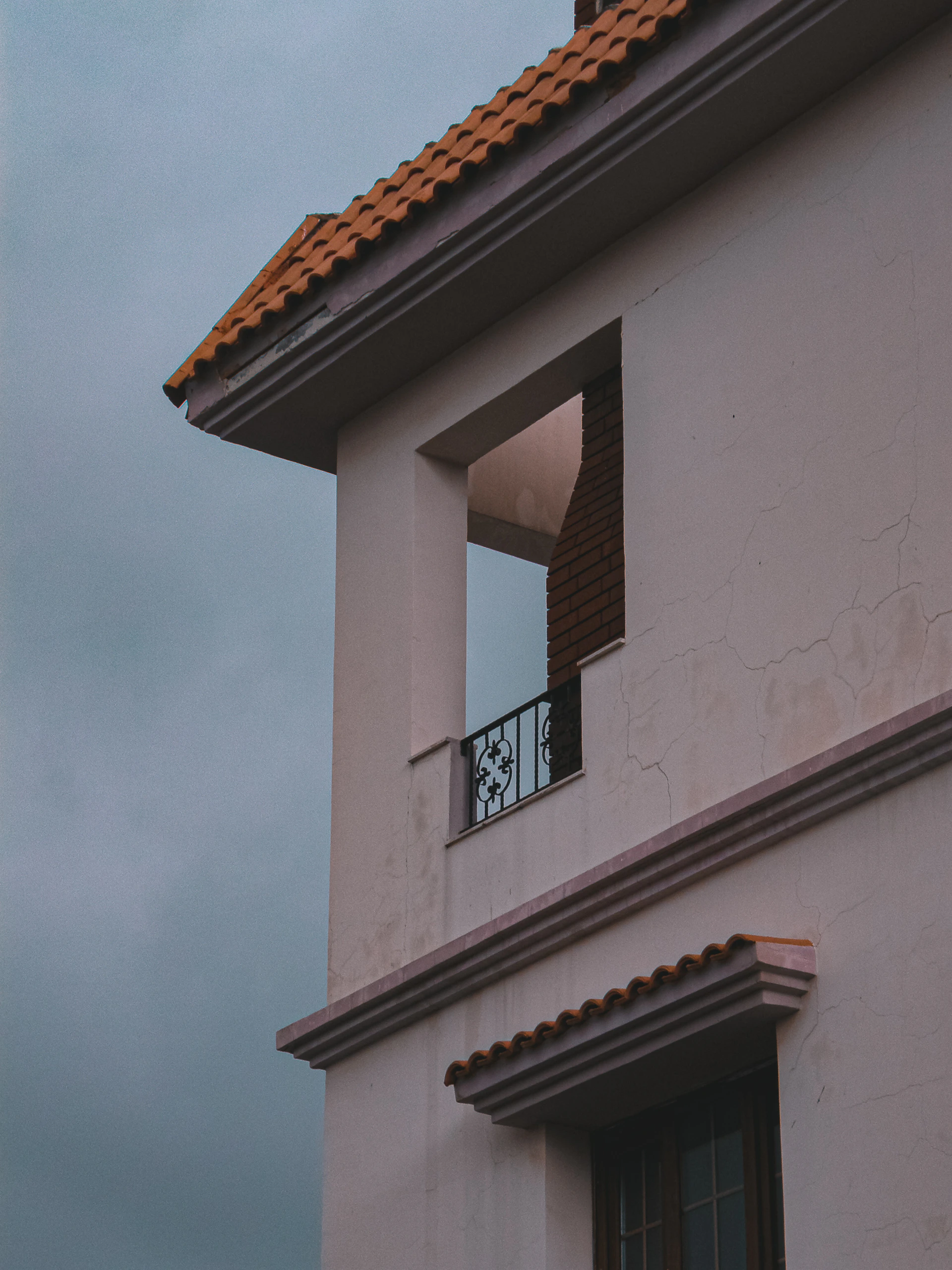 a white building with a red roof and a window