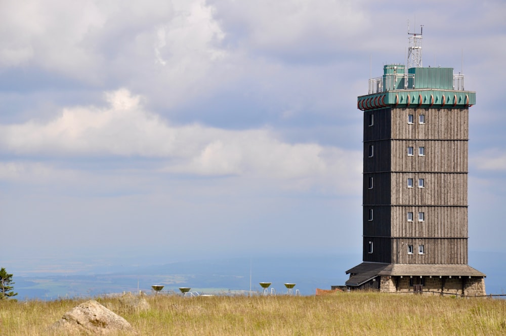 a tall tower sitting on top of a grass covered field