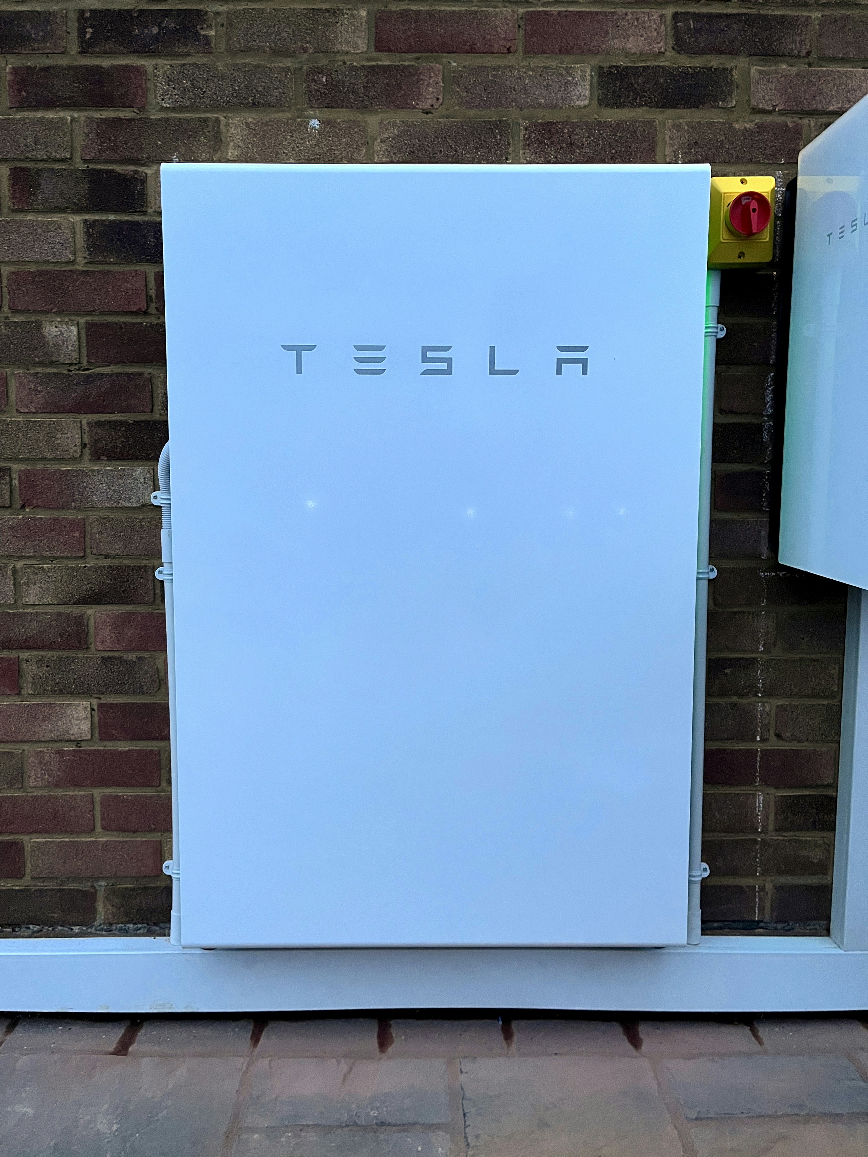 Modern white home battery storage system mounted on garage wall