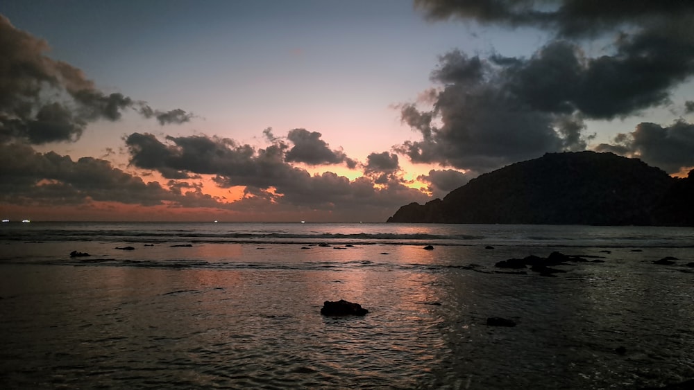 Le soleil se couche sur l’eau de la plage