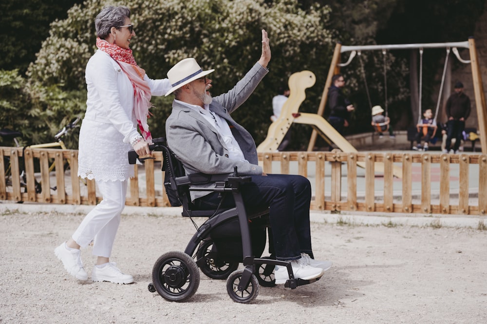 a man sitting in a wheel chair next to a woman