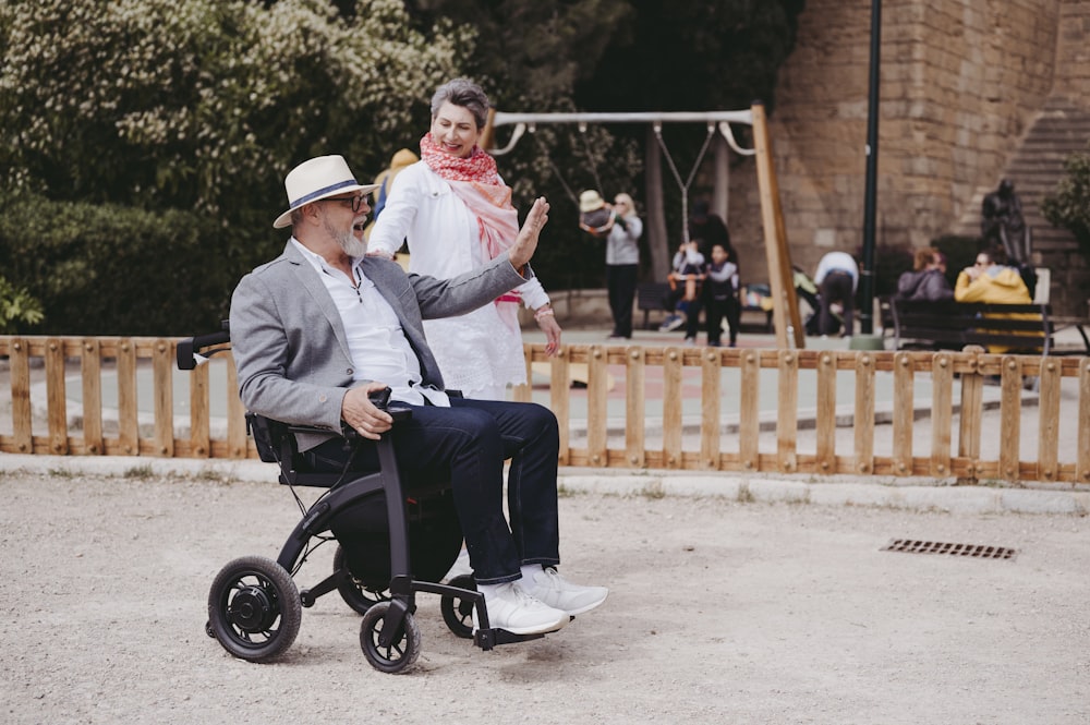a man sitting in a wheel chair next to a woman