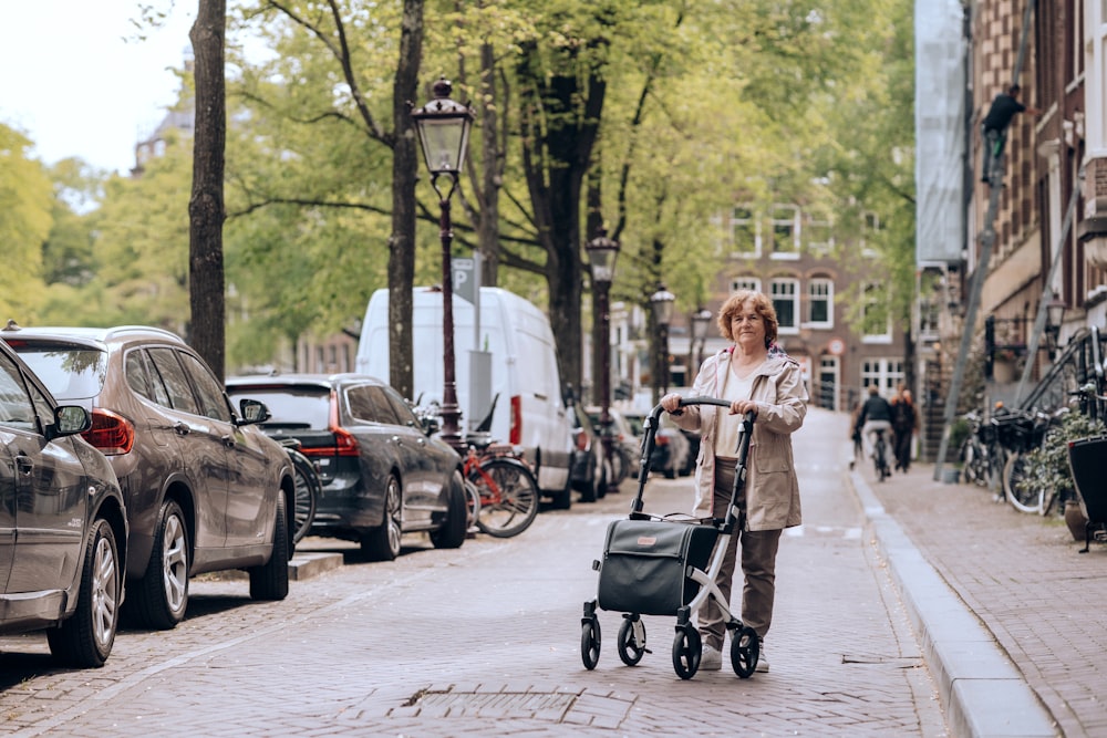 a woman pushing a stroller down a city street