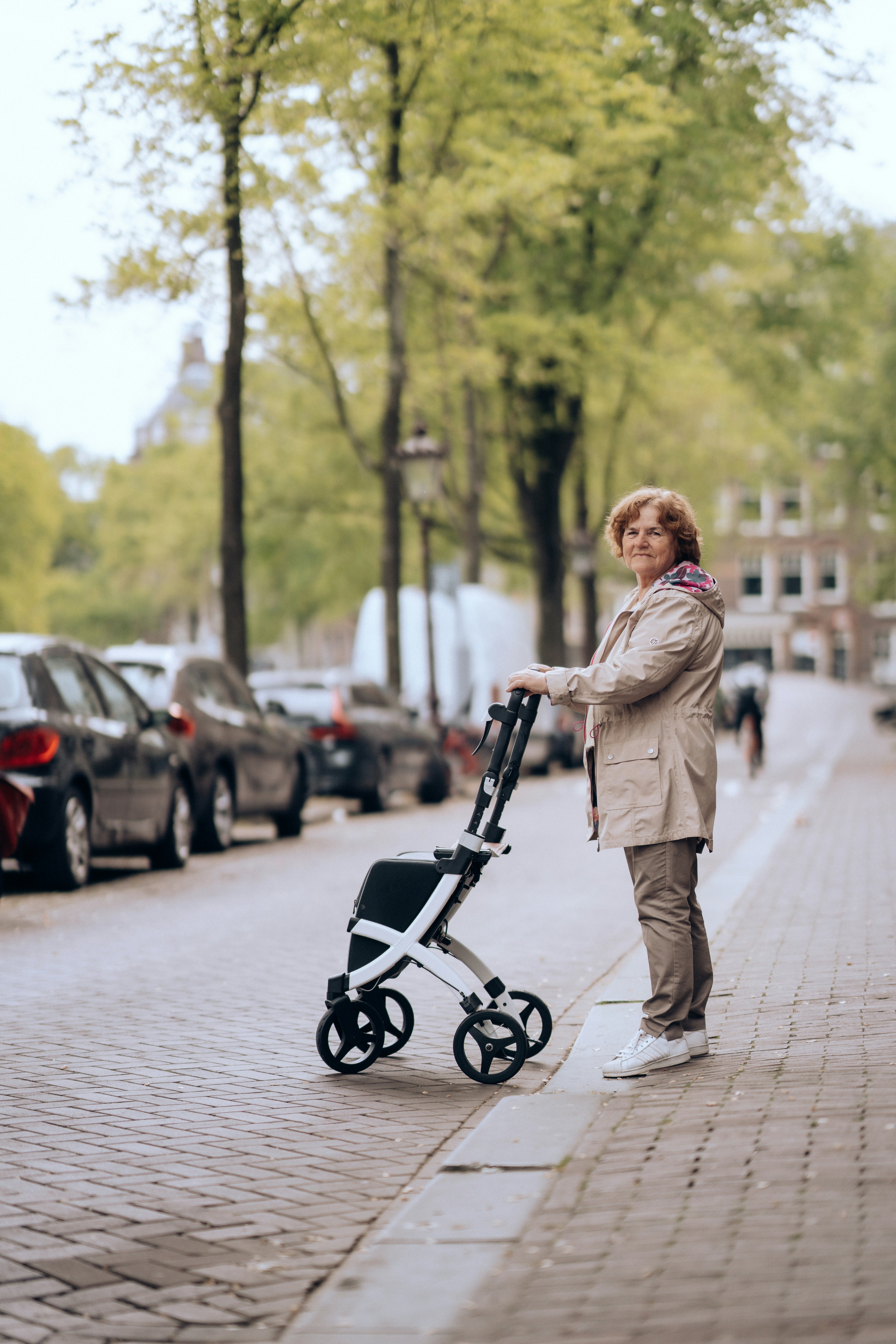 a woman standing next to a stroller on a sidewalk