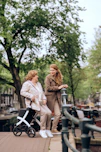 a woman pushing a stroller next to another woman