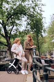a woman pushing a stroller next to another woman