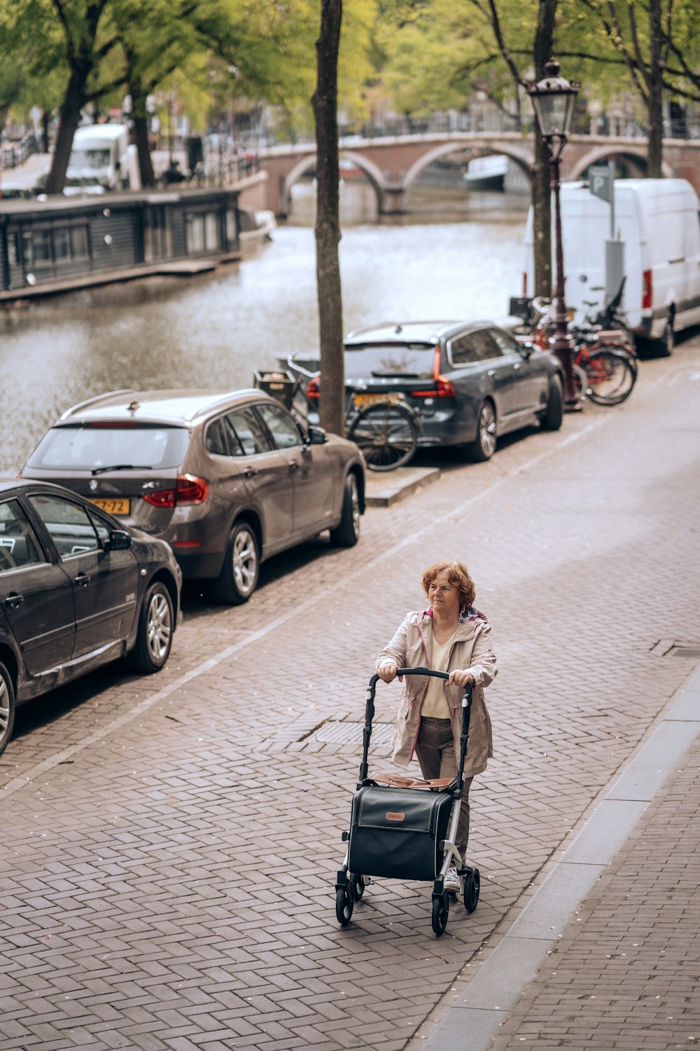 a woman pushing a stroller down a street