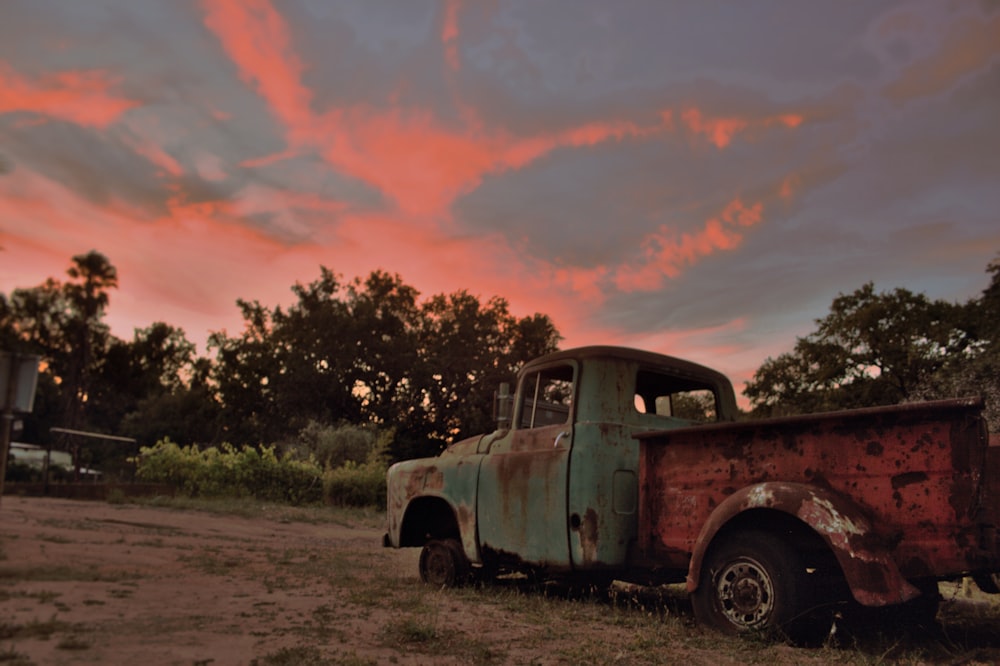an old rusty truck sitting in a field