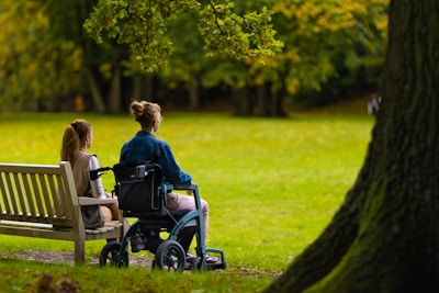 a couple of women sitting on top of a wooden bench
