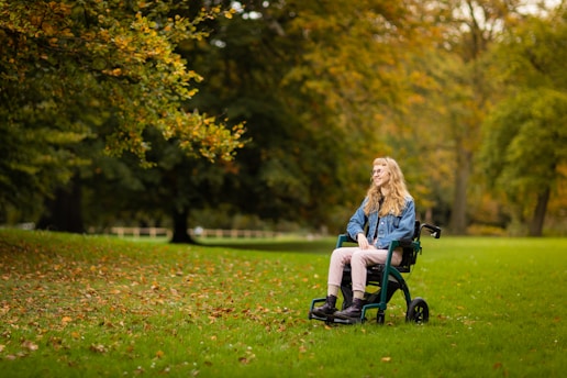 a woman sitting in a wheel chair in a park