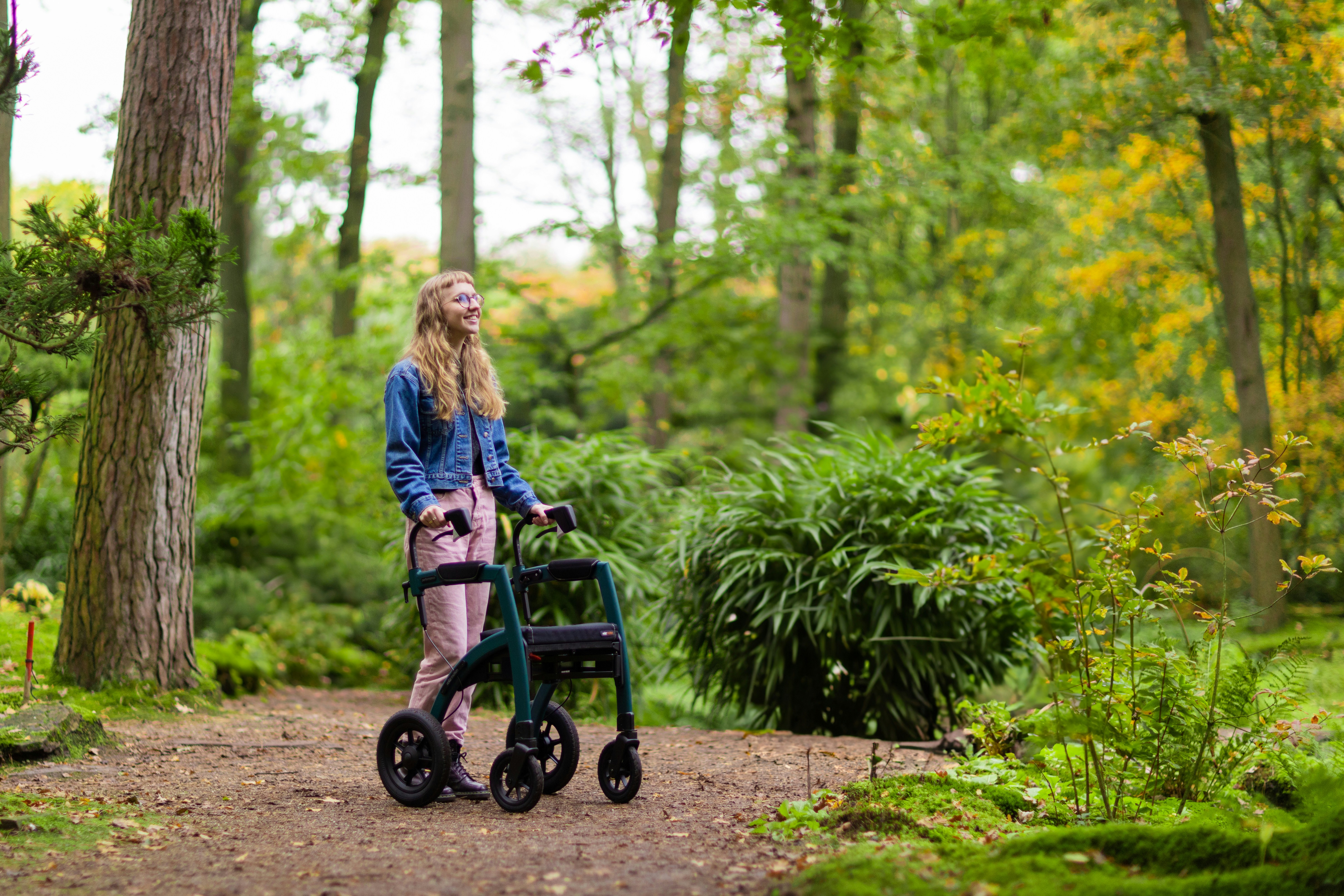 a woman walking with a walker in the woods