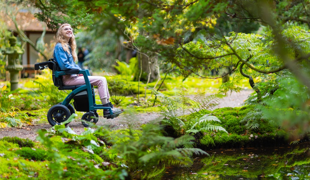 uma mulher sentada em uma cadeira de rodas na floresta