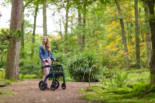 a woman walking with a walker in the woods