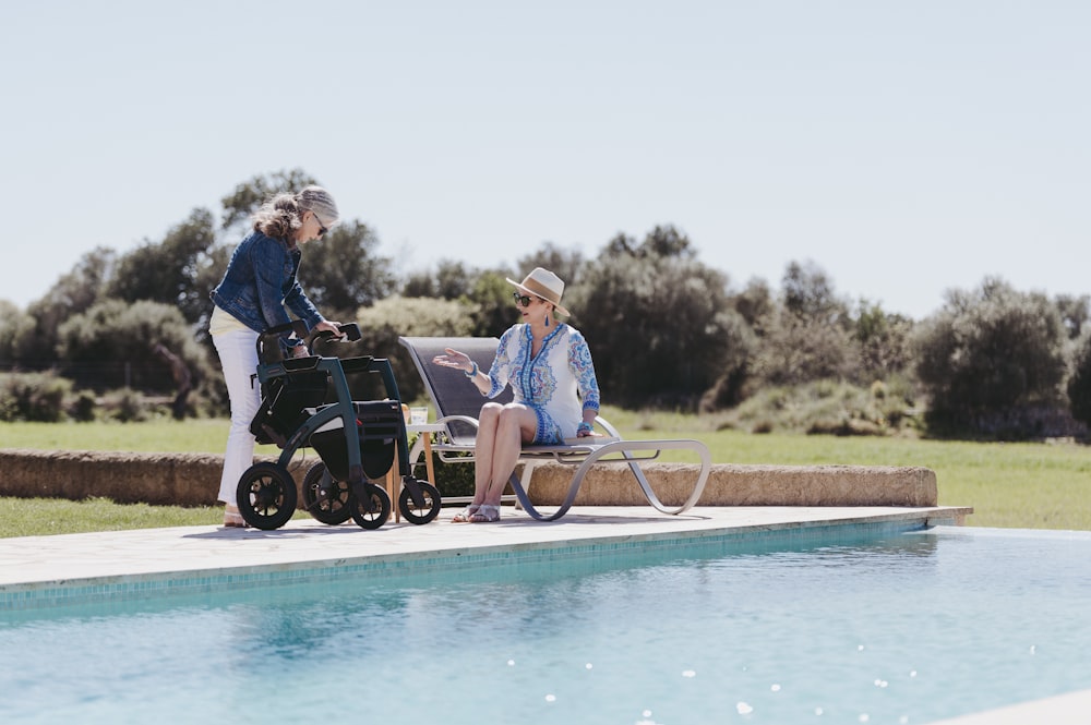 a woman in a wheel chair next to a pool