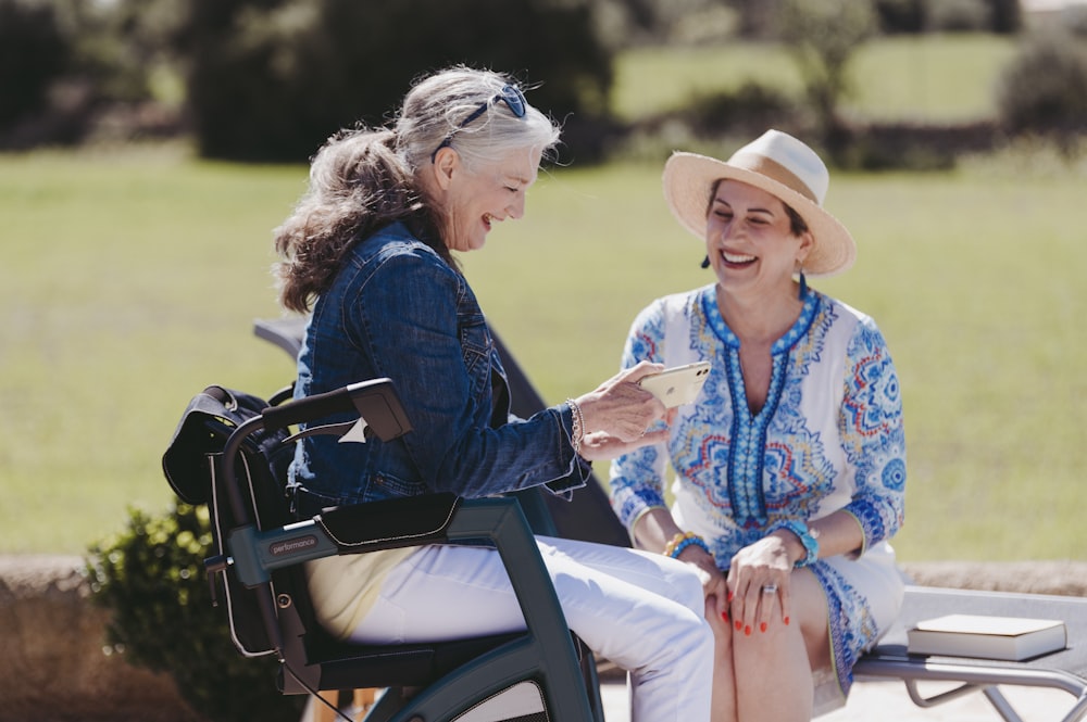 a woman sitting on a bench next to another woman