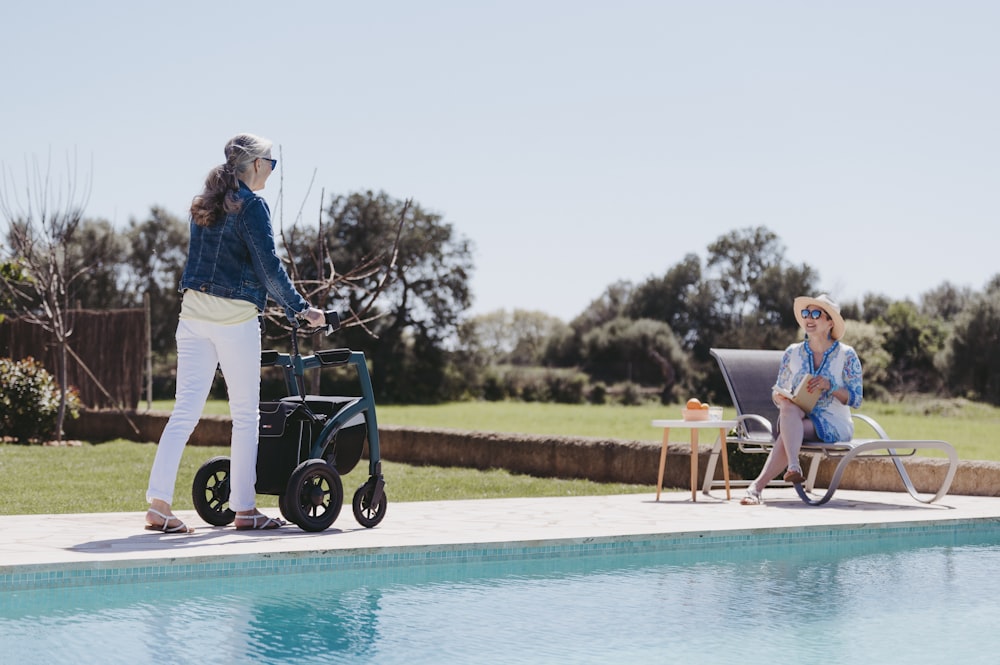 a woman pushing a walker next to a pool